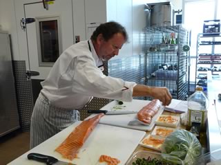 Chef Chris Aerni spreading some fleur de sel on his salmon carpaccio.
